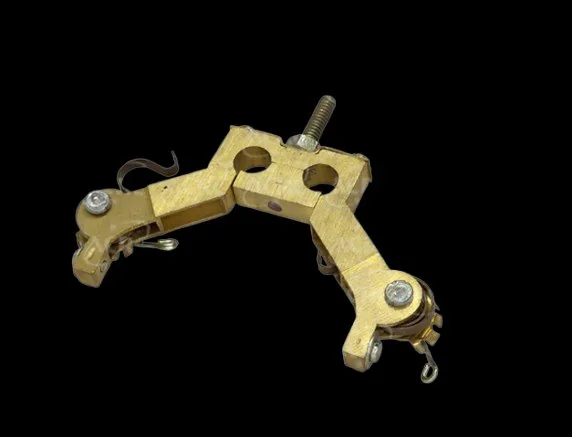 Brass carbon brush holder assembly showing mounting hardware and spring mechanism