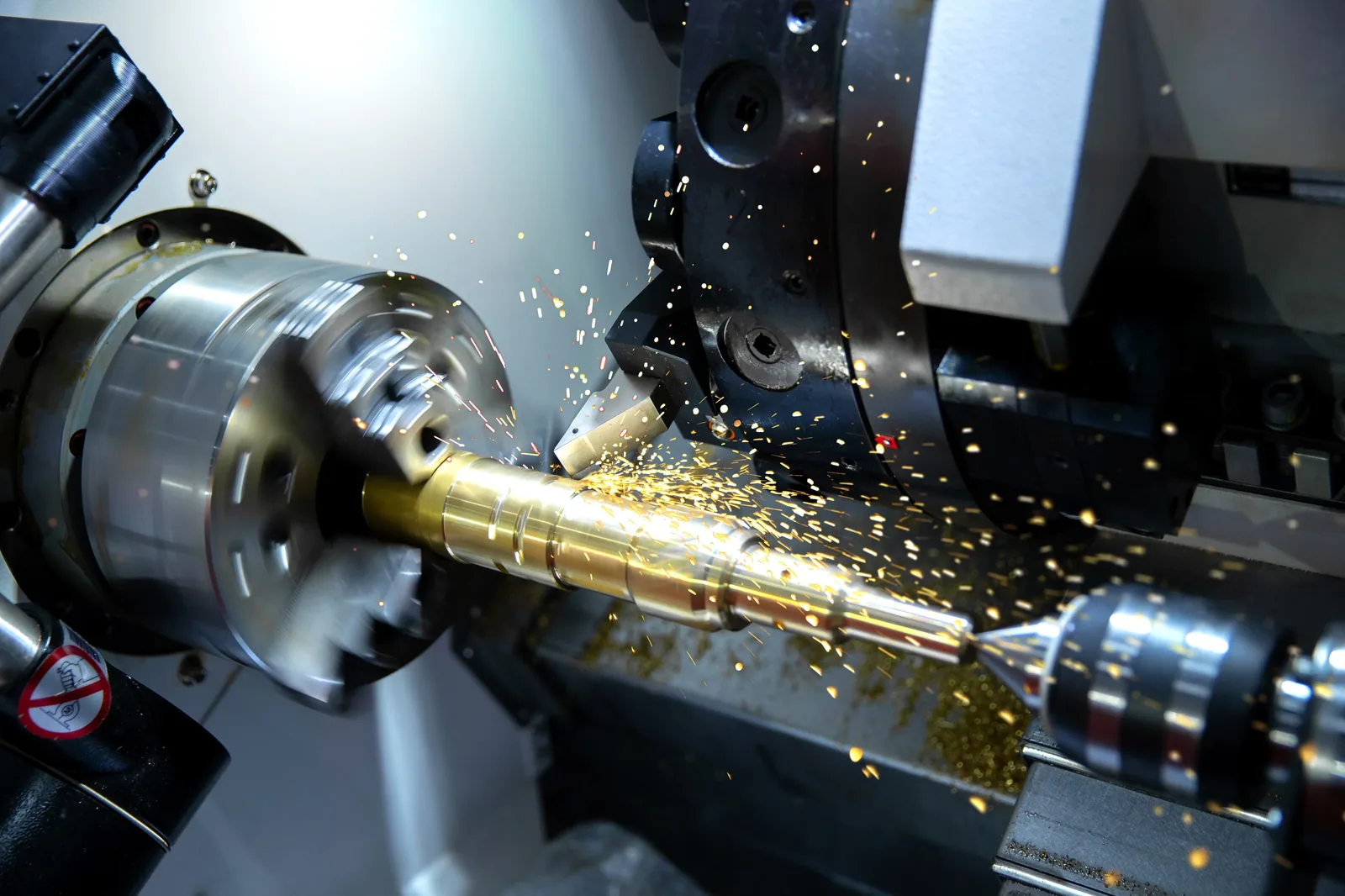 CNC lathe turning a precision component — sparks visible