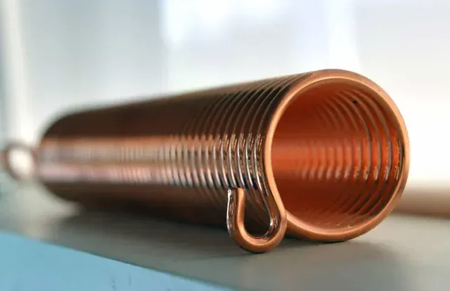 Close-up of a copper torsion spring coil showing precision wound construction
